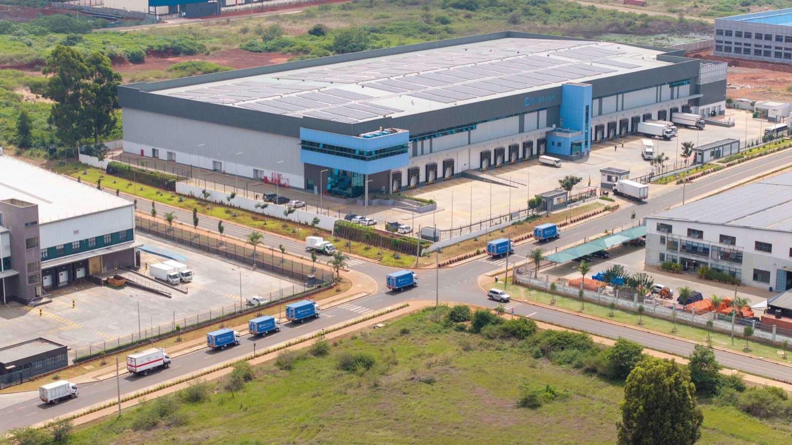 Aerial view of the facility with rooftop solar and the truck fleet
